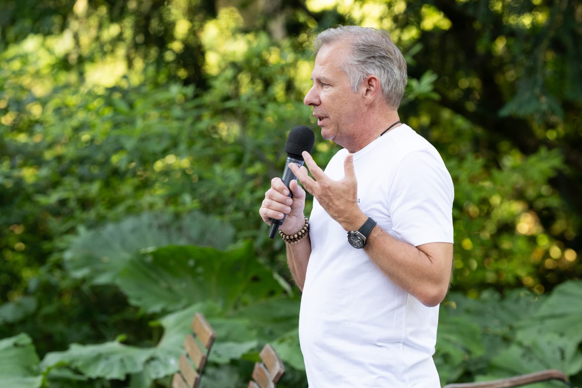 Redner mit Mikrofon im Grünen