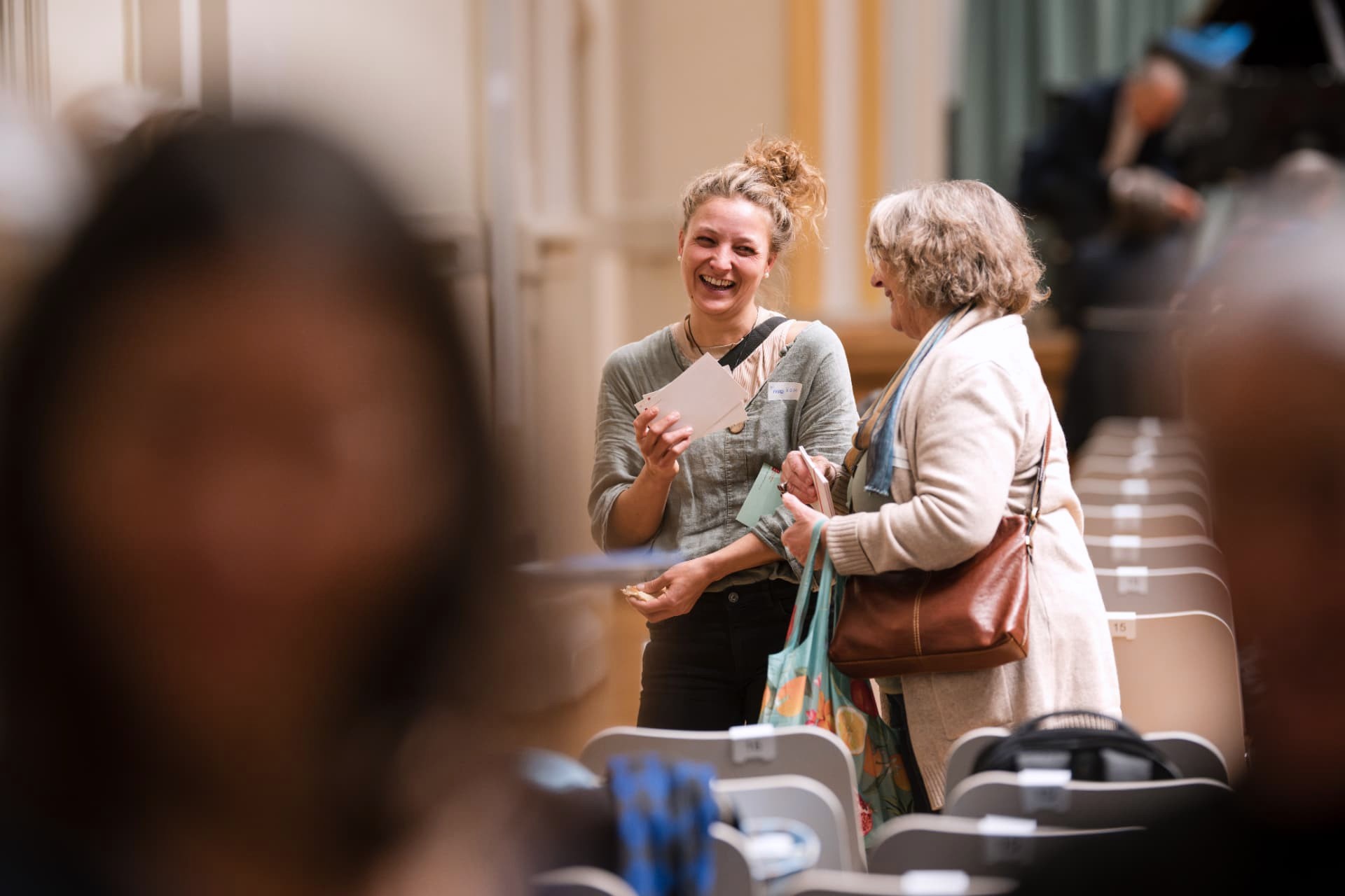Young woman laughing warmly in conversation with an older woman