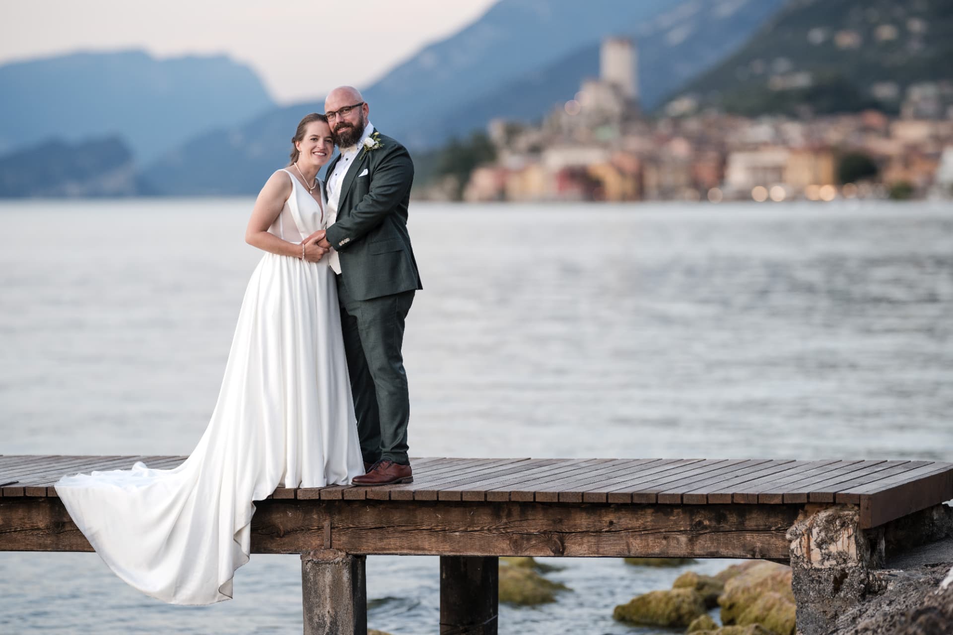 Brautpaar auf dem Steg am Gardasee in der Abenddämmerung
