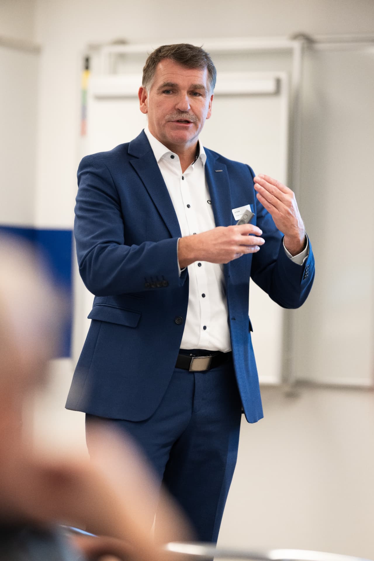 Referent im blauen Anzug spricht vor dem Publikum