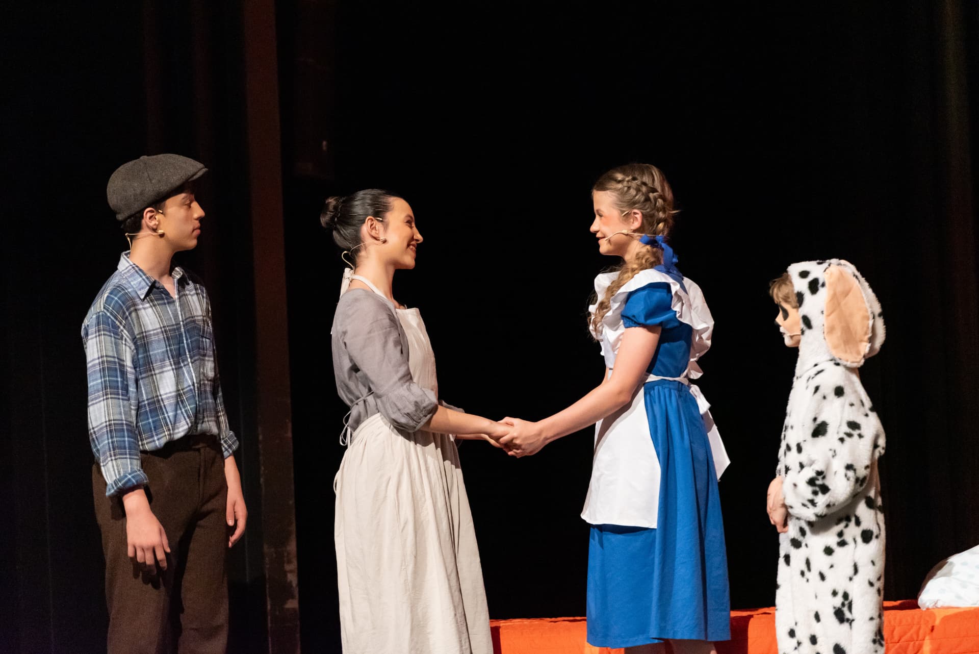 Dorothy mit Familie und Toto in einer Szene im warmen Spotlicht