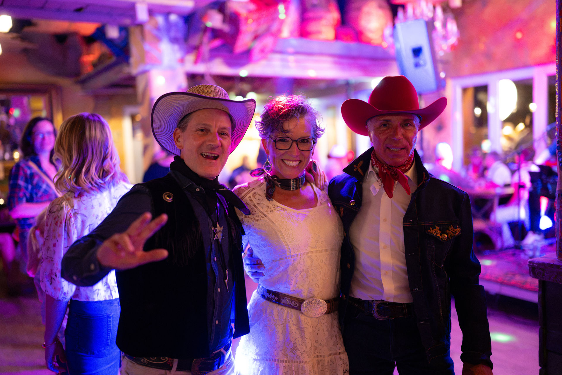 Drei Gäste posieren in Cowboy-Outfits