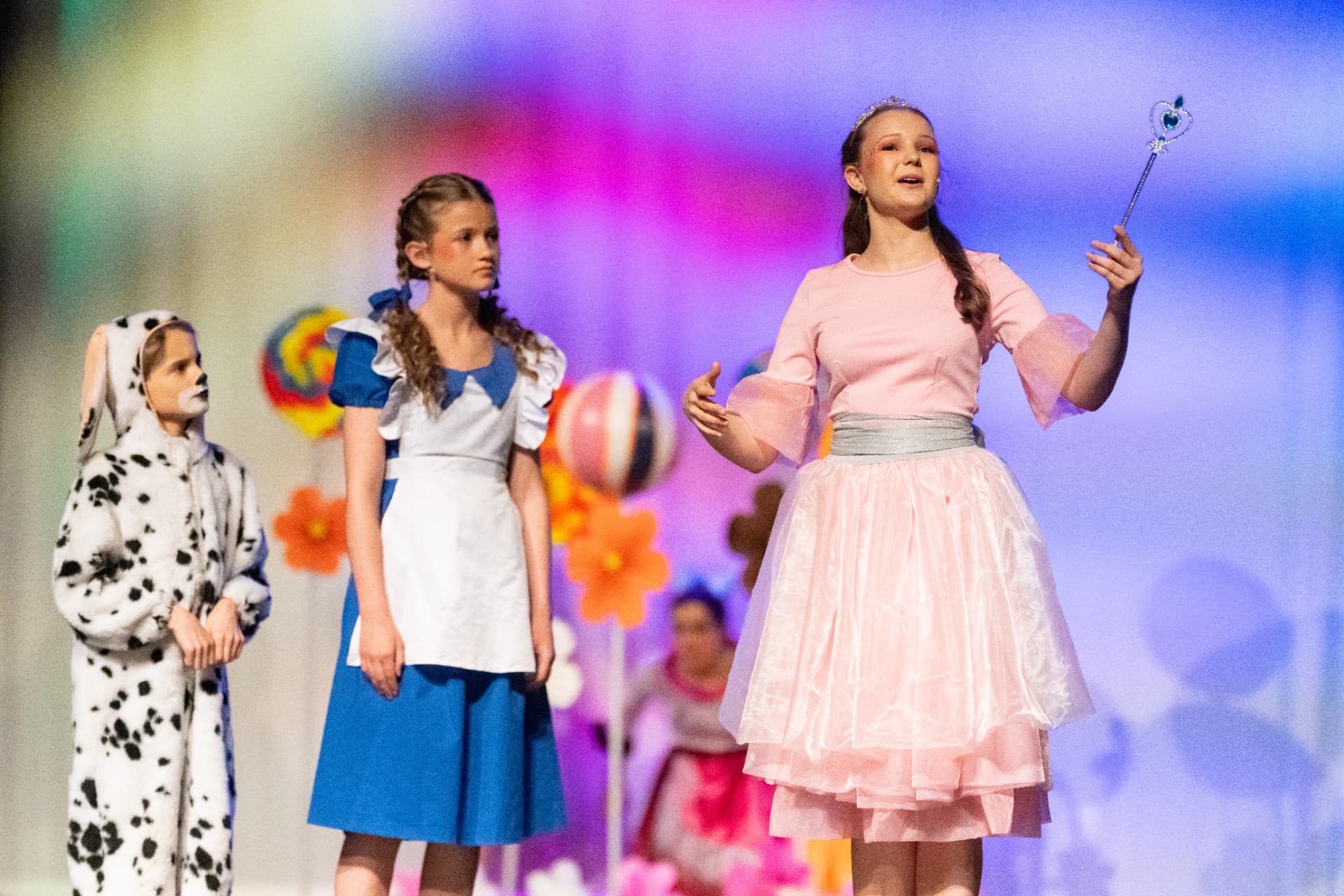 Dorothy, Toto und Glinda in einer hell ausgeleuchteten Szene des Kindermusicals