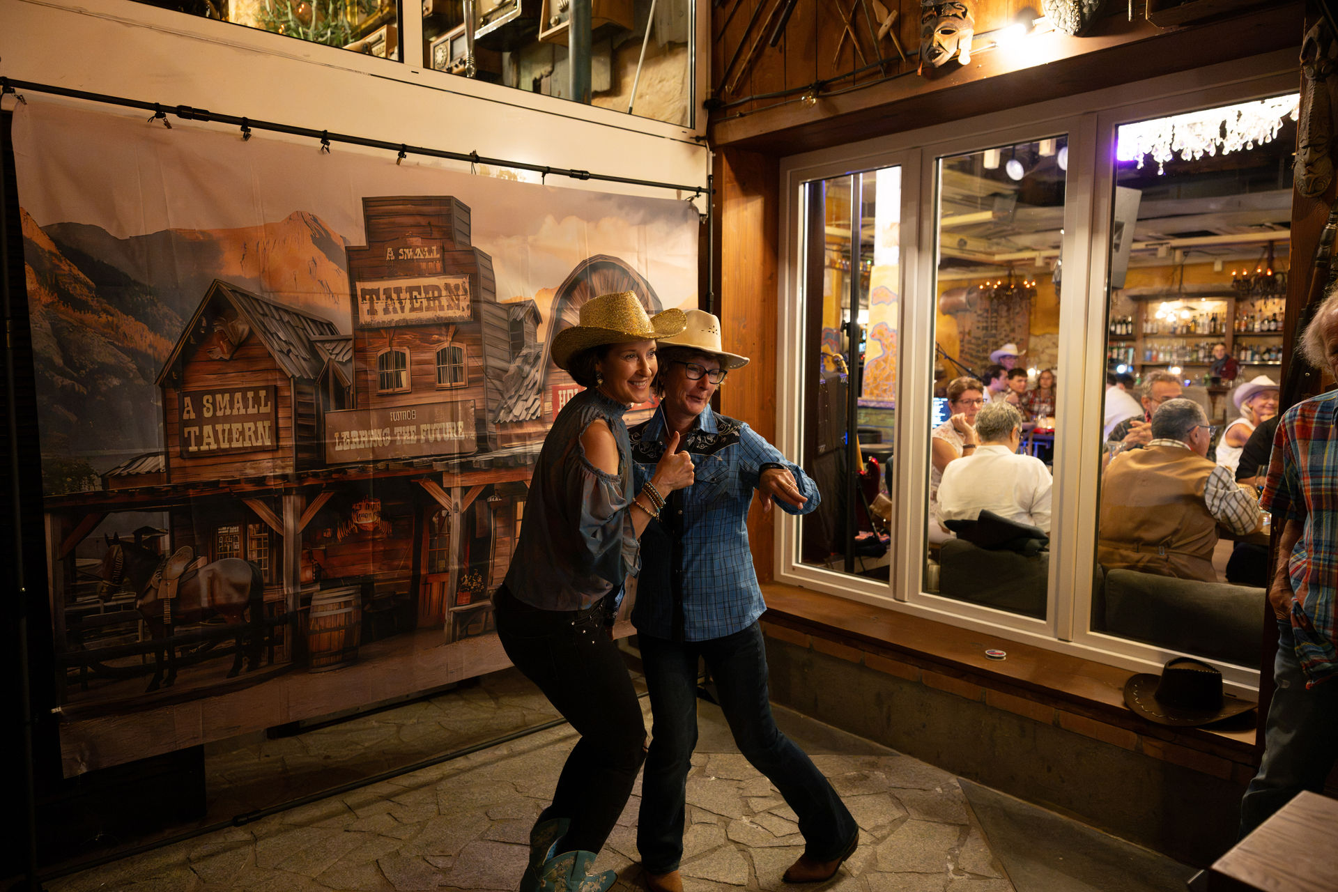 Zwei Frauen tanzen vor der Saloon-Kulisse