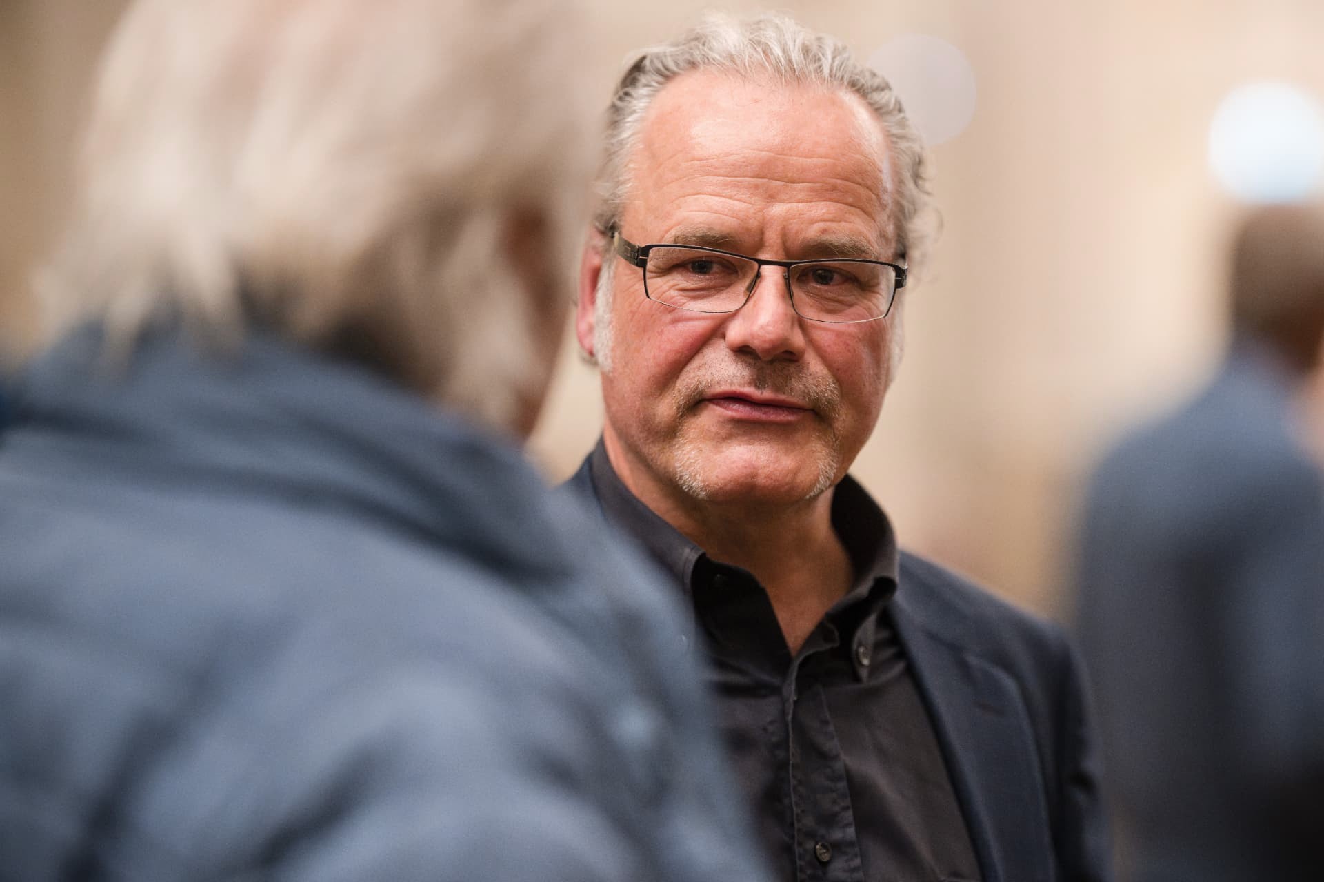 Man with glasses in conversation in the foyer