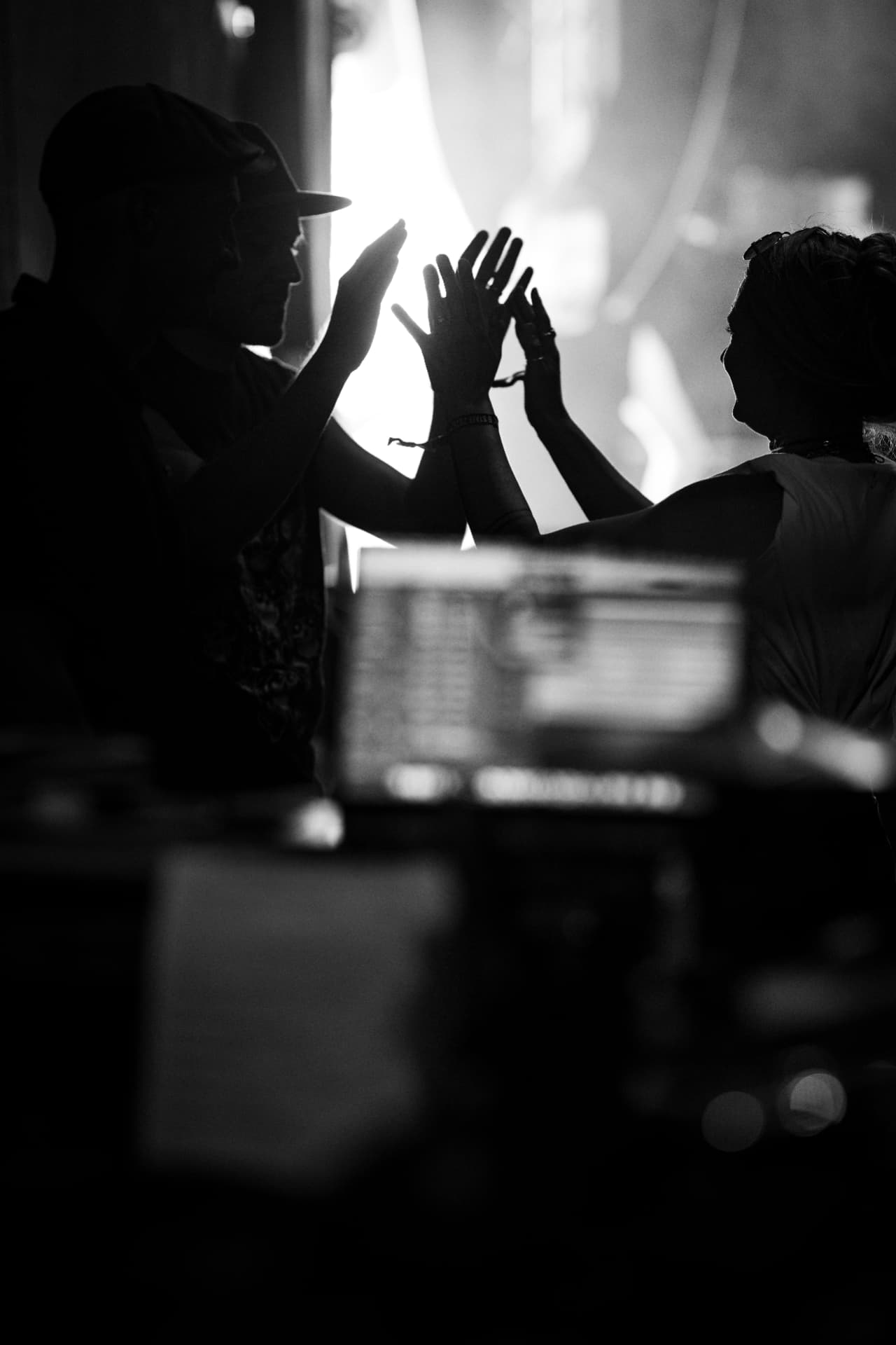 High-Five im Gegenlicht hinter der Bühne, Schwarzweiss