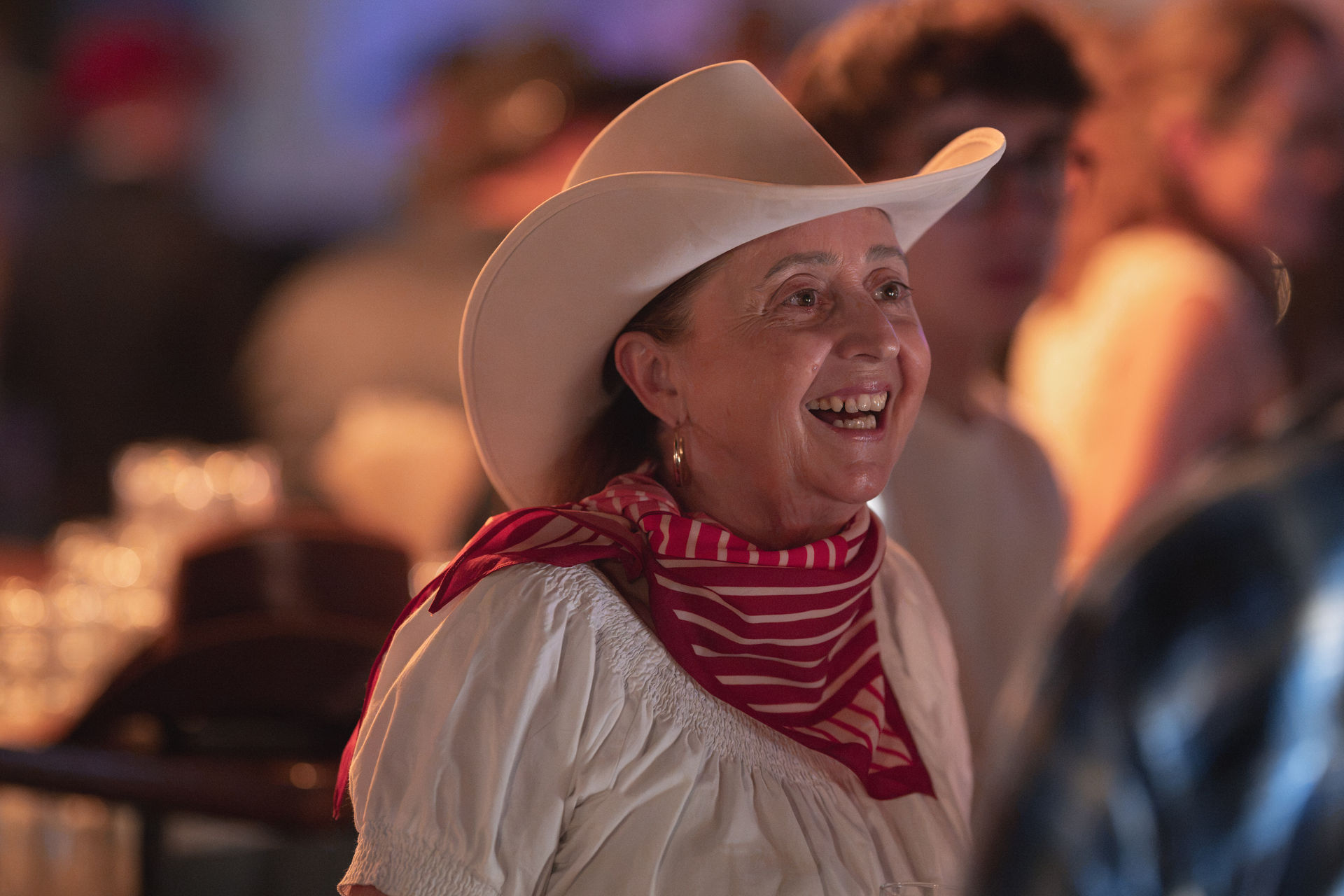 Lachende Gästin mit weissem Cowboyhut