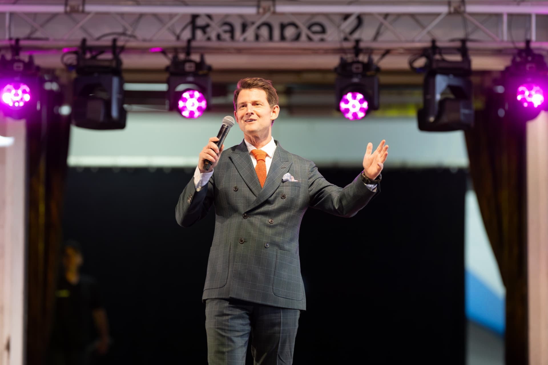 Speaker with a microphone on stage at the Weisbrod-Zürrer anniversary celebration in Hausen am Albis