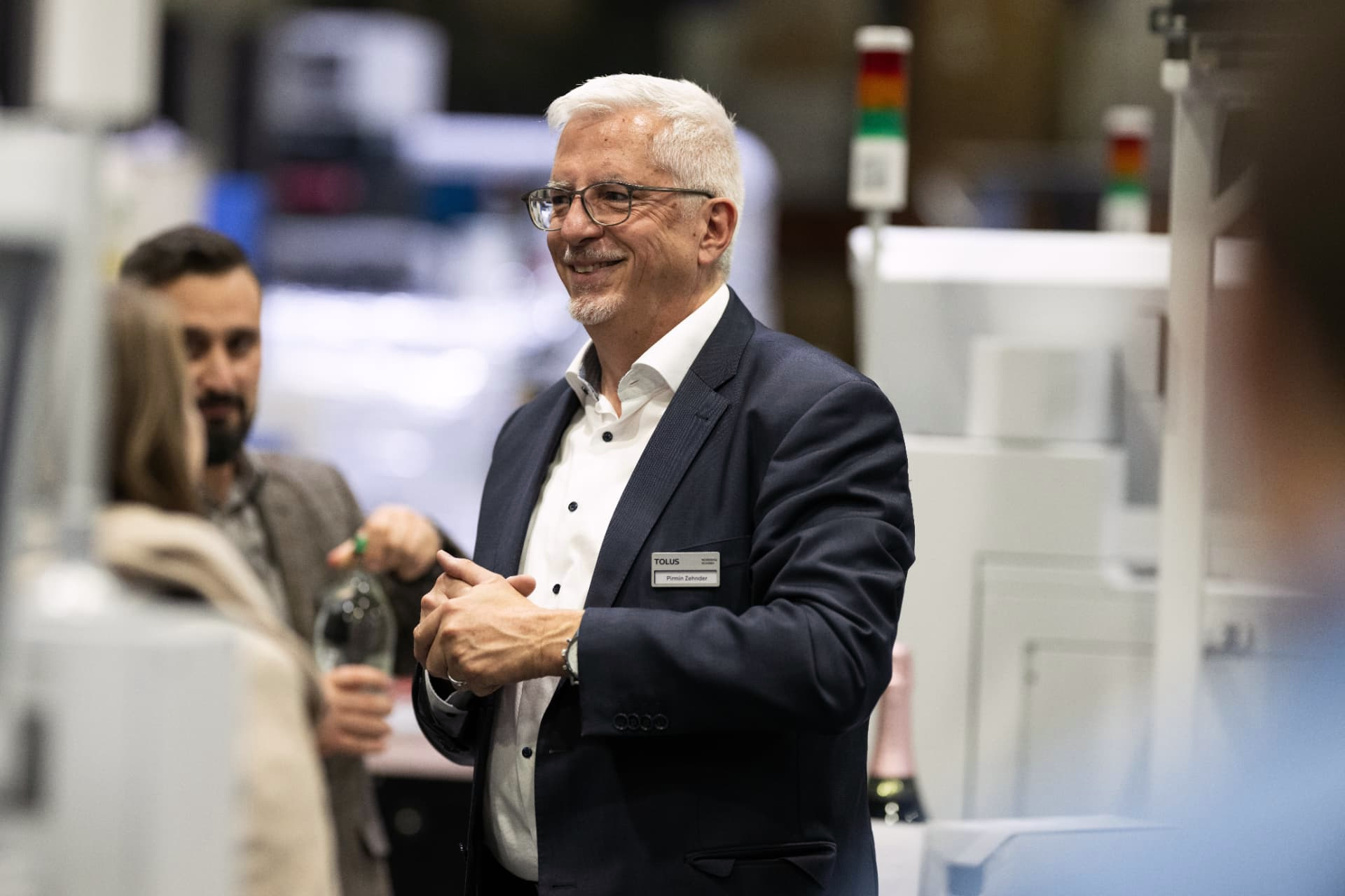 Lächelnder Gast im Gespräch an einer Ausstellung